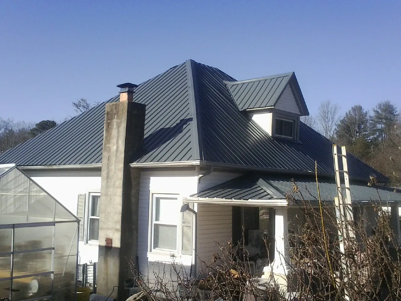 Dark blue standing seam metal roof on a white farmhouse with dormer — Slate & Tile Roof Repair by Roofing Brothers in Twain Harte