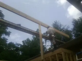 Carpenter setting a ridge beam over a new addition frame — Ice Dam Removal by Roofing Brothers in Twain Harte