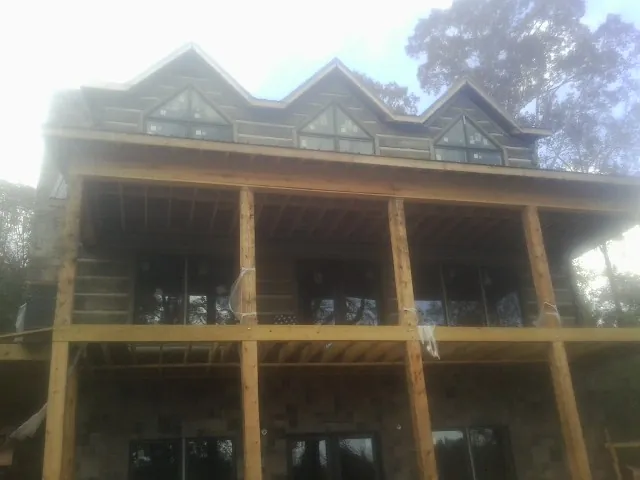 Dormers and porch framing on a large log home under construction — Roof Coating work by our crew in Twain Harte