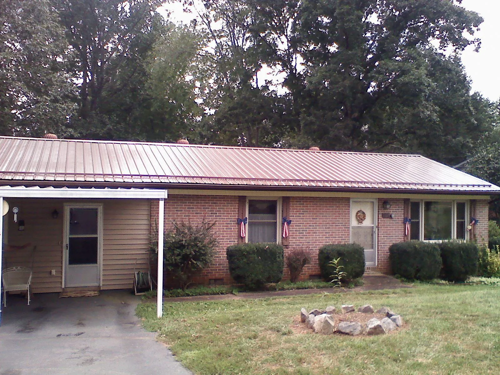 Bronze metal roof and carport on a brick ranch home — Roof Repair work by our crew in Twain Harte